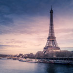 beautiful-wide-shot-eiffel-tower-paris-surrounded-by-water-with-ships-colorful-sky_181624-5118